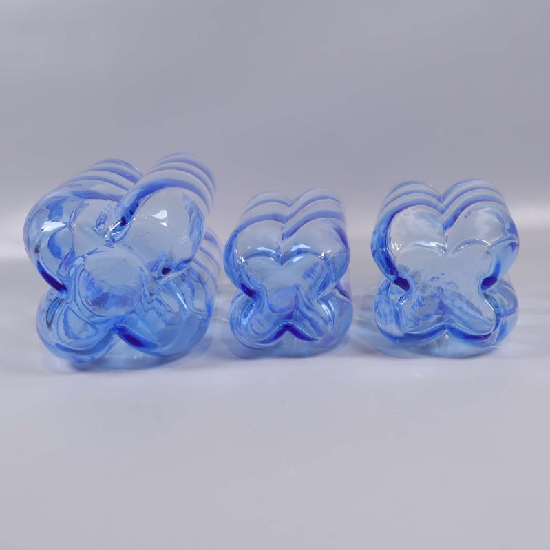 Undersidan av tre blå glasvaser med blomformad bas