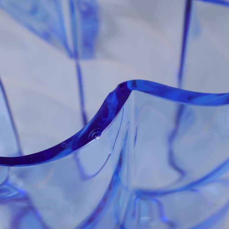 Detalj närbild av blå glasvas med små naggar