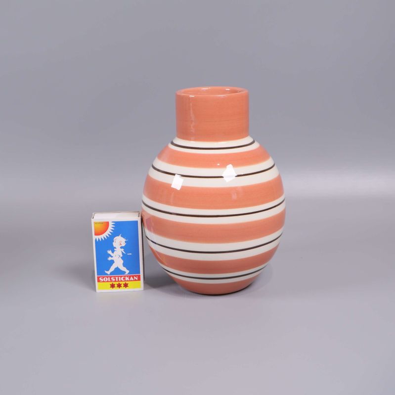 Randig vas jämte tändsticksask för storleksreferens