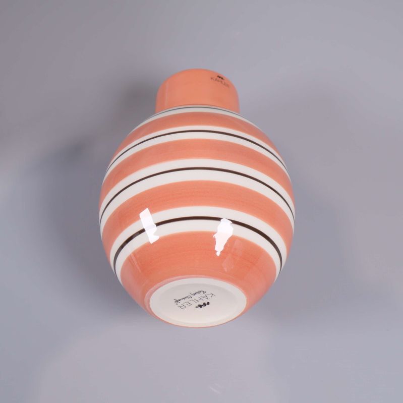 Vas i aprikos och vitt liggande, visar rändernas mönster tydligt