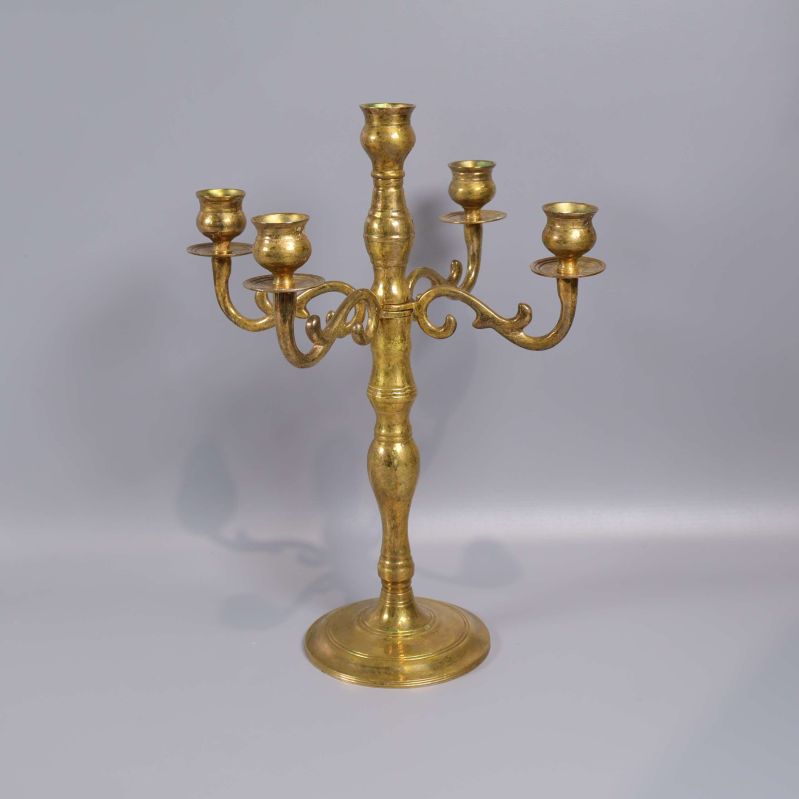 Femarmad ljusstake i blank mässing på grå bakgrund