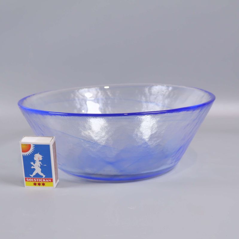 Blå och transparent glasskål med tändsticksask som storleksjämförelse