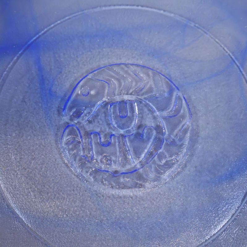 Detalj av botten på glasskål med präglat konstnärligt motiv (UHV)
