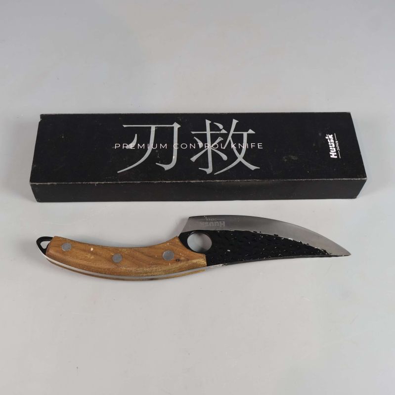 Kniv med trähandtag och svart ask bredvid