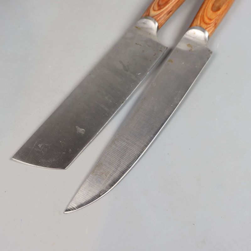 Närbild på två knivblad med brunmönstrade handtag