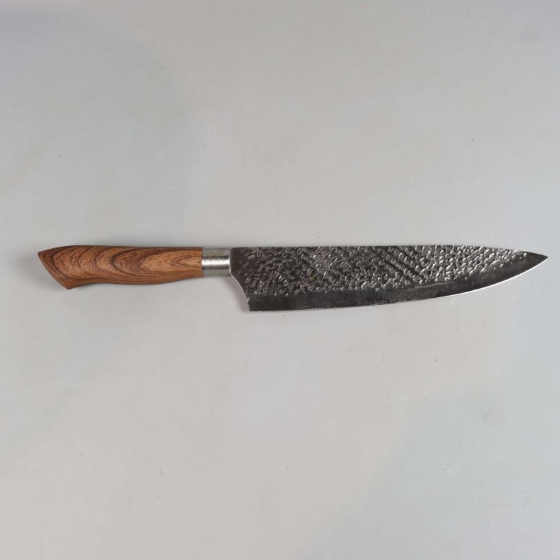 Japansk kockkniv med hamrat blad och trähandtag på grå yta