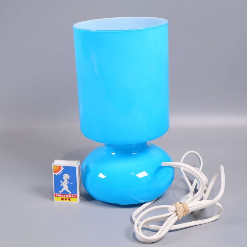 Blå bordslampa tillsammans med tändsticksask för storleksreferens