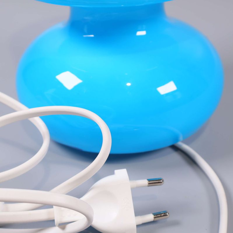 Närbild på vit kontakt och sladd till blå bordslampa