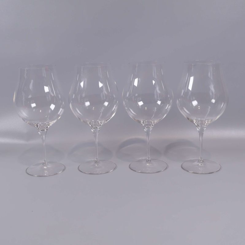 Fyra kupade vinglas på rad mot neutral bakgrund