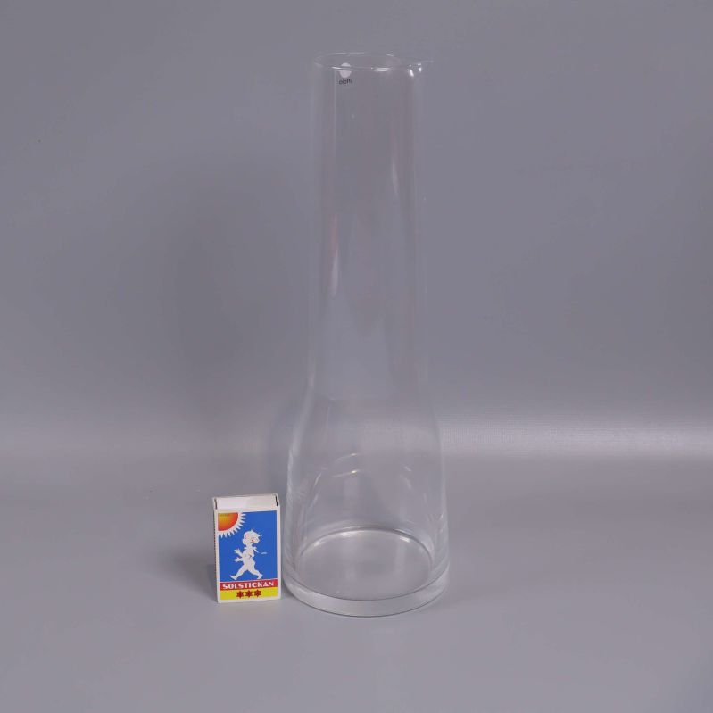 Karaff i klart glas bredvid tändsticksask för skala