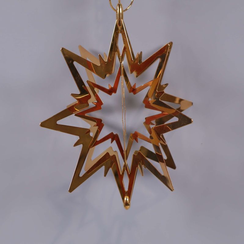 Guldfärgad metallstjärna mot grå bakgrund