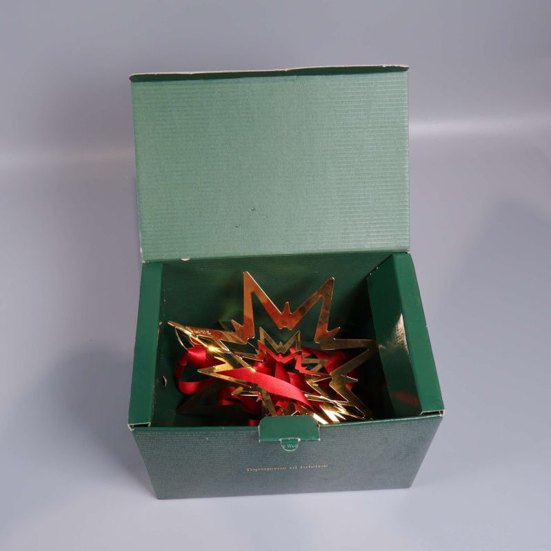 Julstjärna med röd rosett i öppen grön ask