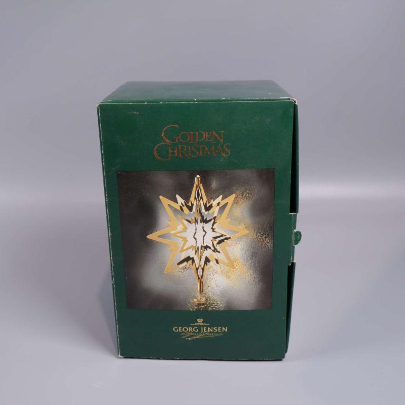 Stängd grön kartong med guldtext och motiv