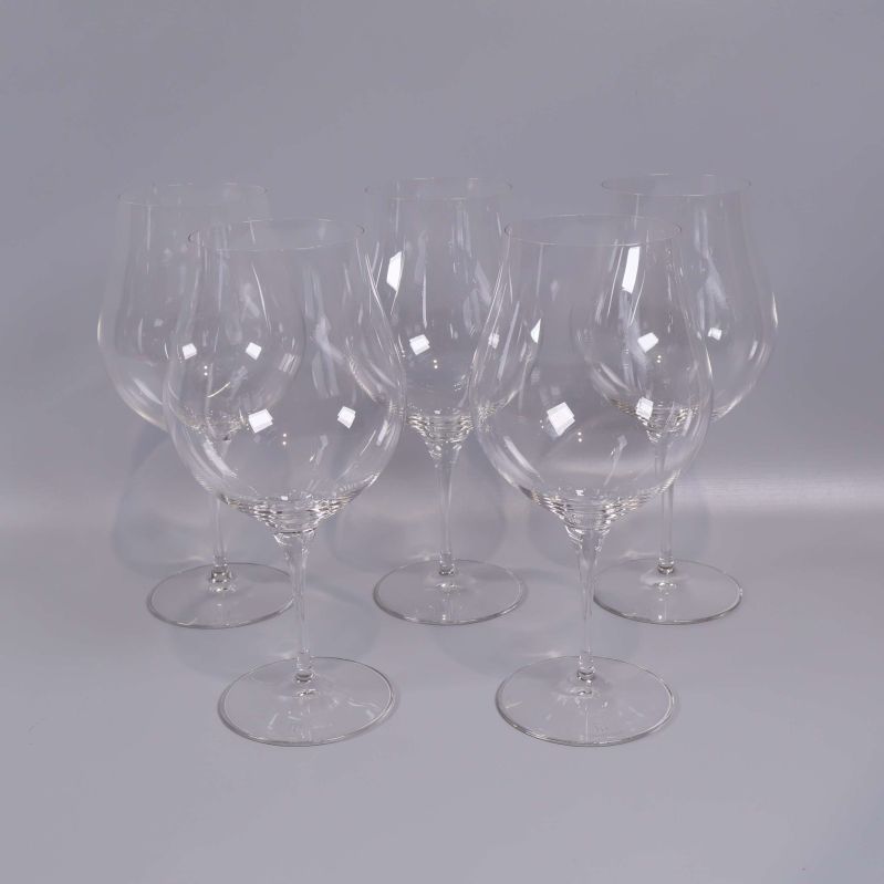 Fem vinglas uppställda mot ljus bakgrund