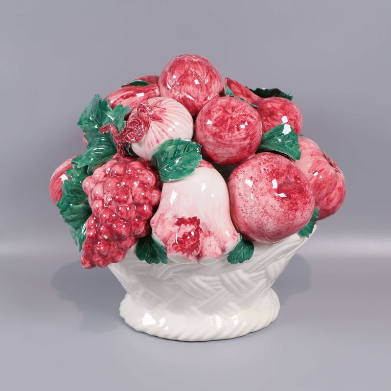 Porslin skål fylld med röda frukter och gröna blad