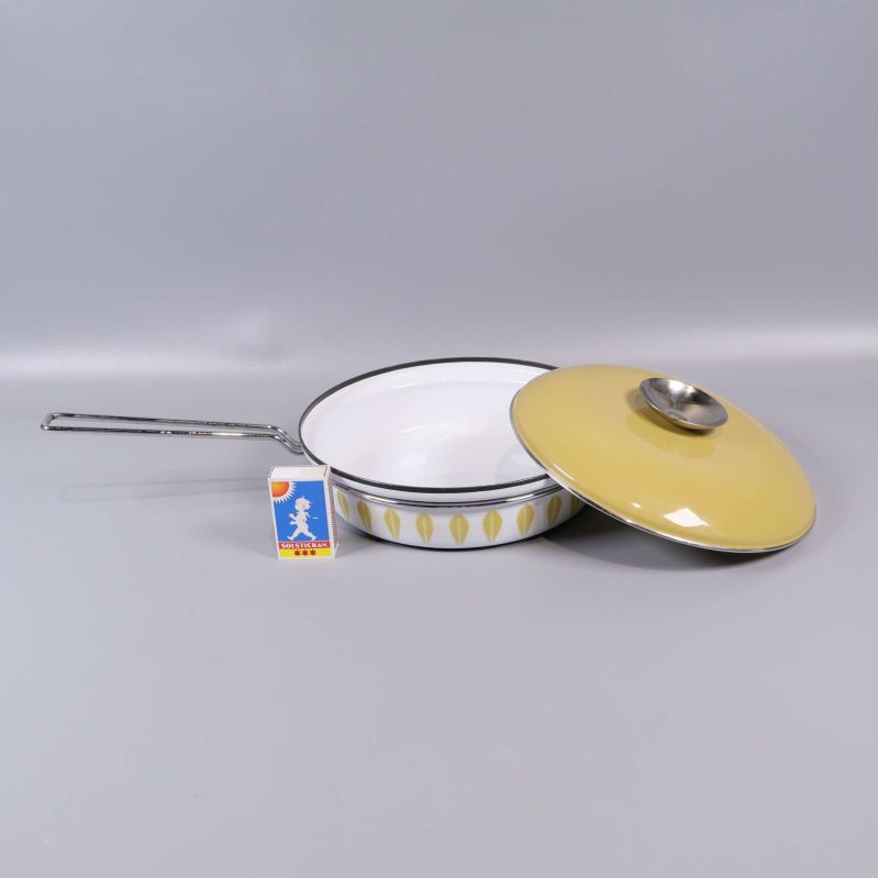 Stekpanna med avtaget lock och tändsticksask för storleksreferens