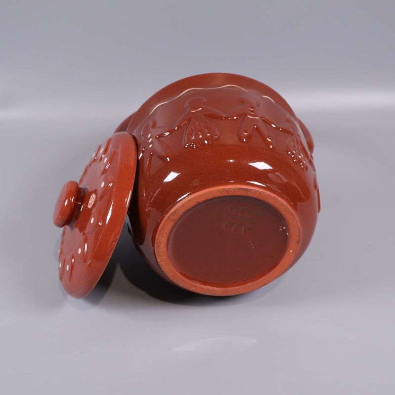 Keramikburk liggande på sidan med locket bredvid