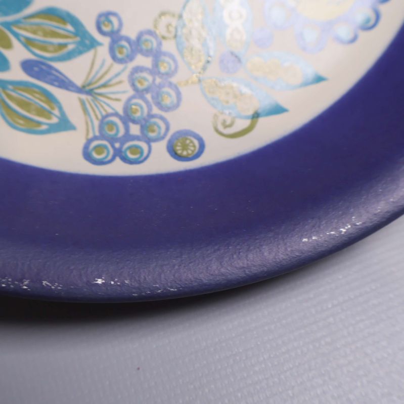 Närbild på blommönstrad kant med små bruksspår