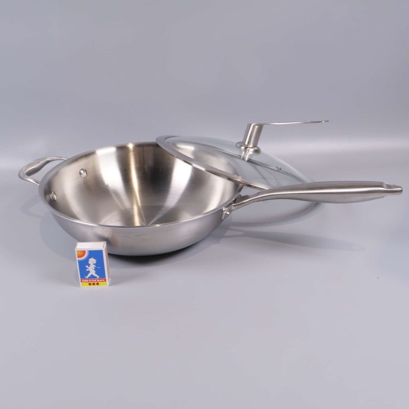 Wokpanna i metall med tillhörande glaslock och tändsticksask