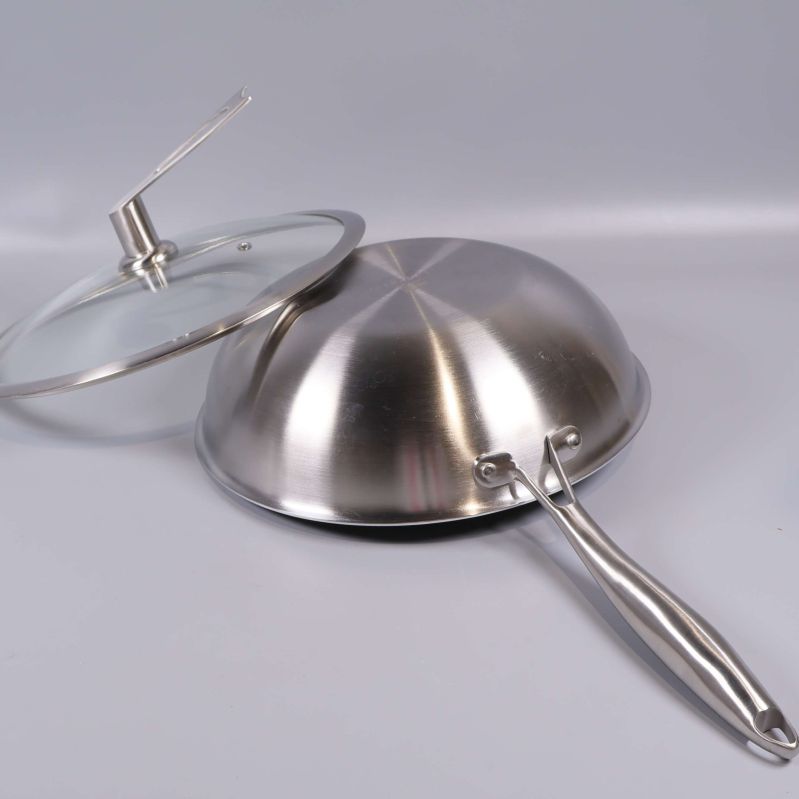 Wokpanna vänd upp och ner med glaslock bredvid