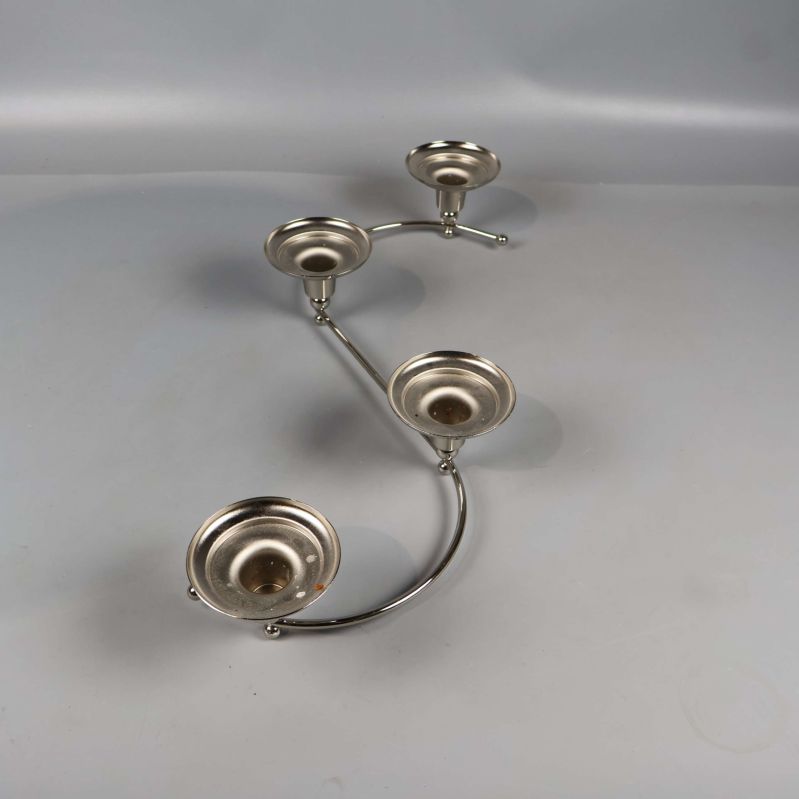 S-formad ljushållare i blank metall med fyra ljusplatser