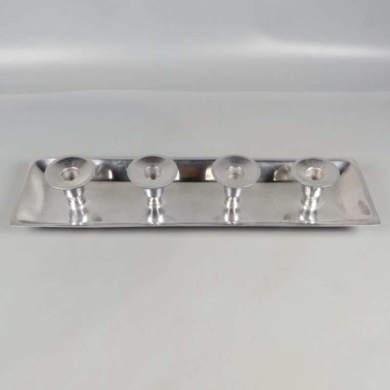 Ljusbricka i metall sedd rakt framifrån med fyra hållare