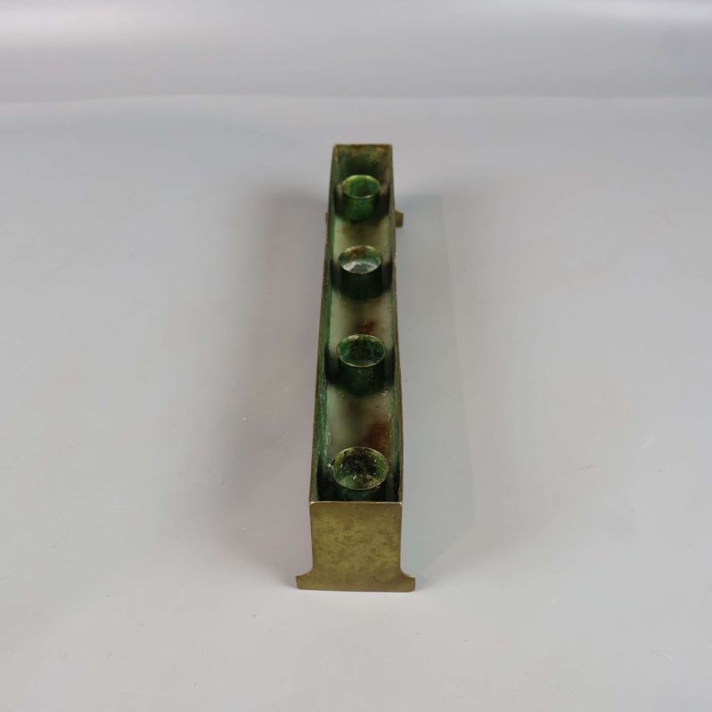 Avlång mässingsljusstake sedd från kortsidan ovanifrån