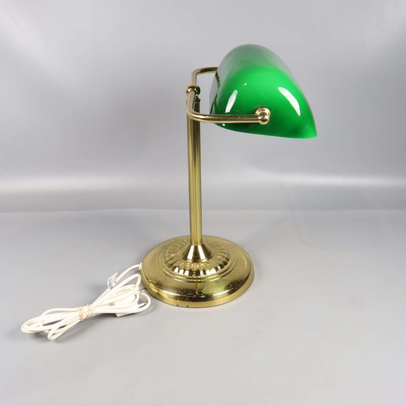 Bordslampa med grön skärm och vit sladd fotograferad snett framifrån