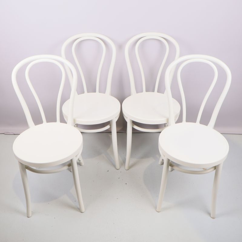 Fyra vita stolar med böjda ryggstöd i grupp