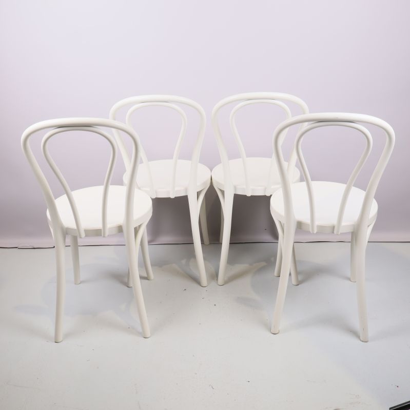 Fyra vita stolar fotograferade bakifrån