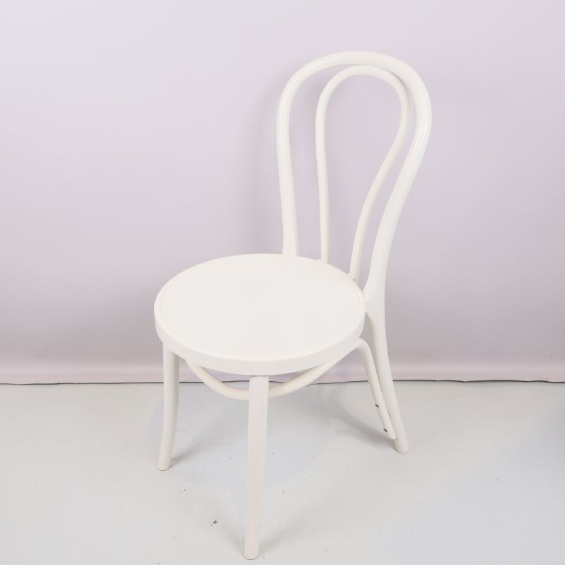 Närbild på en ensam vit stol med böjd rygg