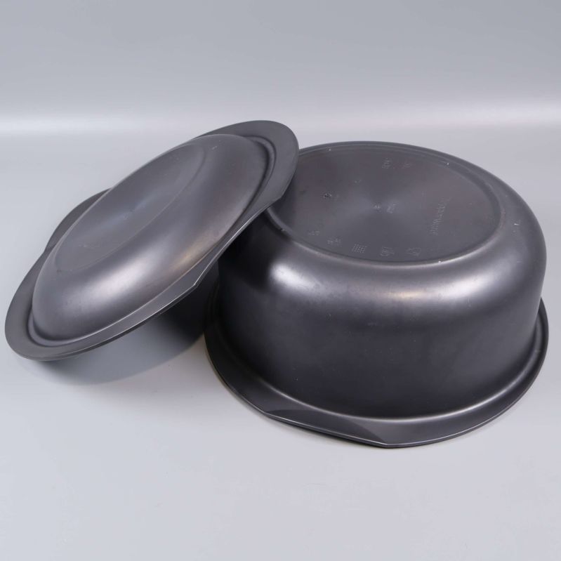 Svart gryta och lock stående upp och nervända