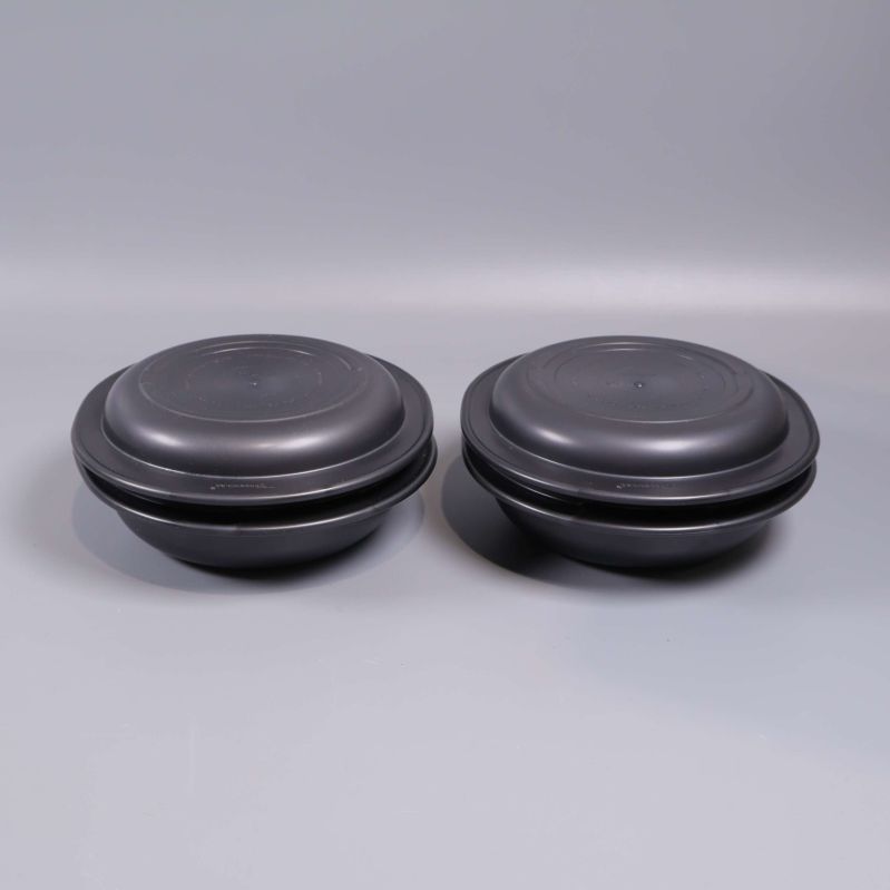 Två staplade svarta skålar fotograferade från sidan