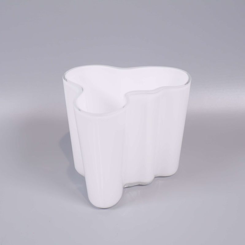 Vit vågig vas stående på ljusgrå bakgrund