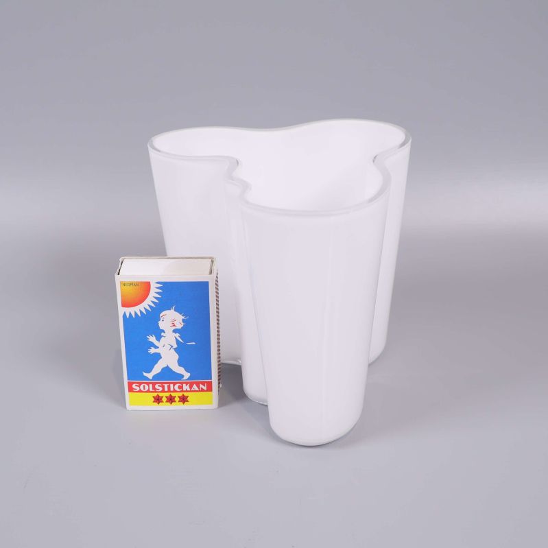 Vit vas placerad bredvid tändsticksask för storleksjämförelse