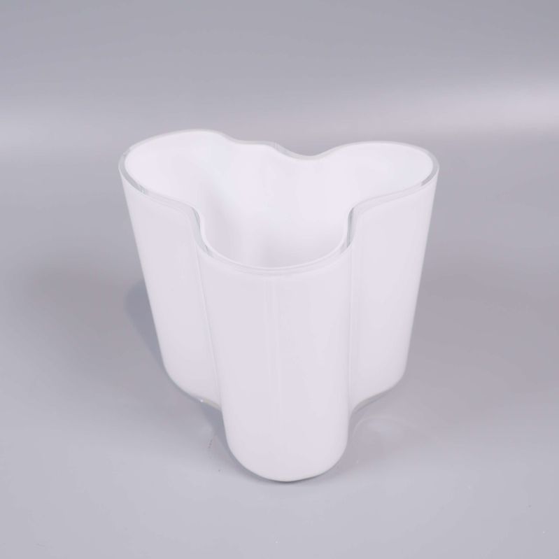 Vit glasvas i närbild med tydlig vågig design