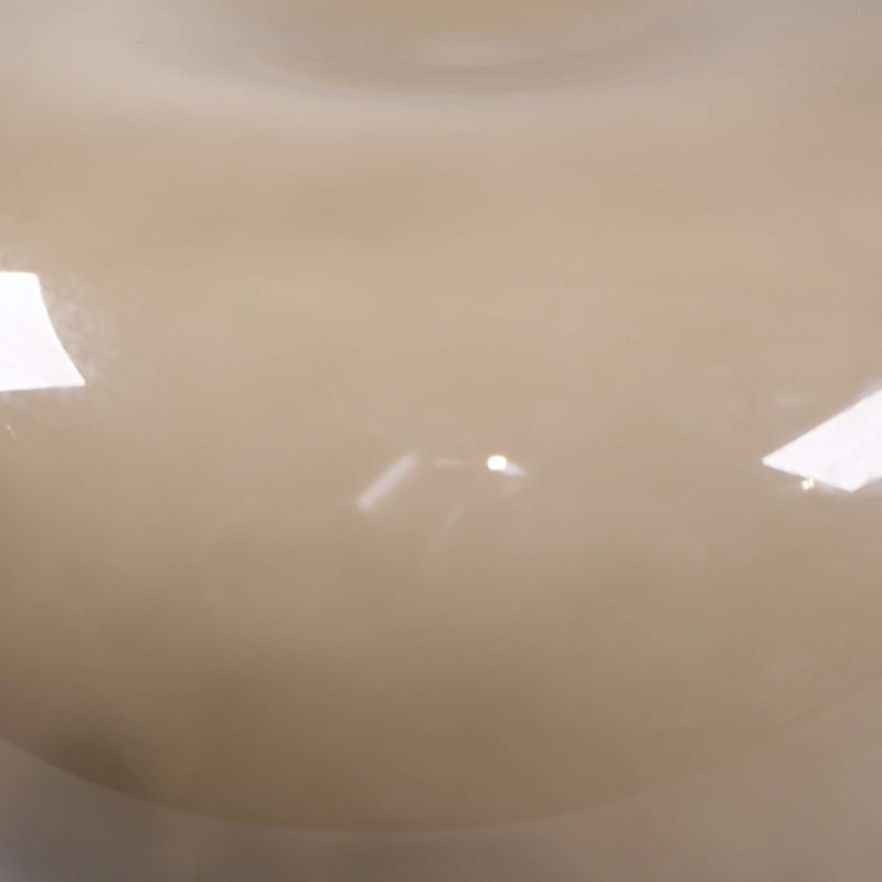 Närbild på beige lampskärm med ytskada