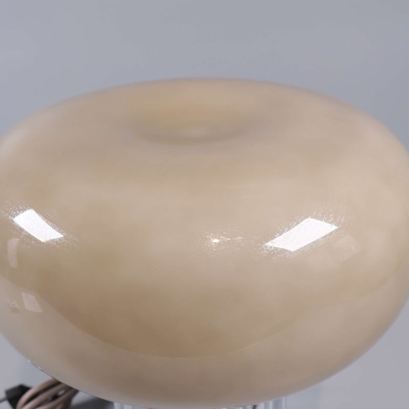 Närbild på bordslampa med rund form och blank yta