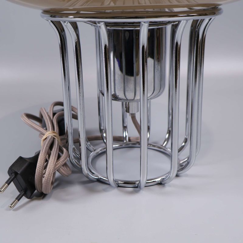 Närbild på den kromade metallbasen och lampans sladd