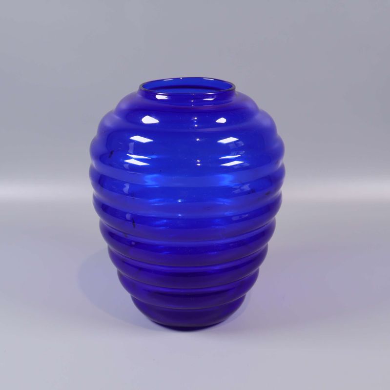 Blå vas med räfflad yta mot ljus bakgrund