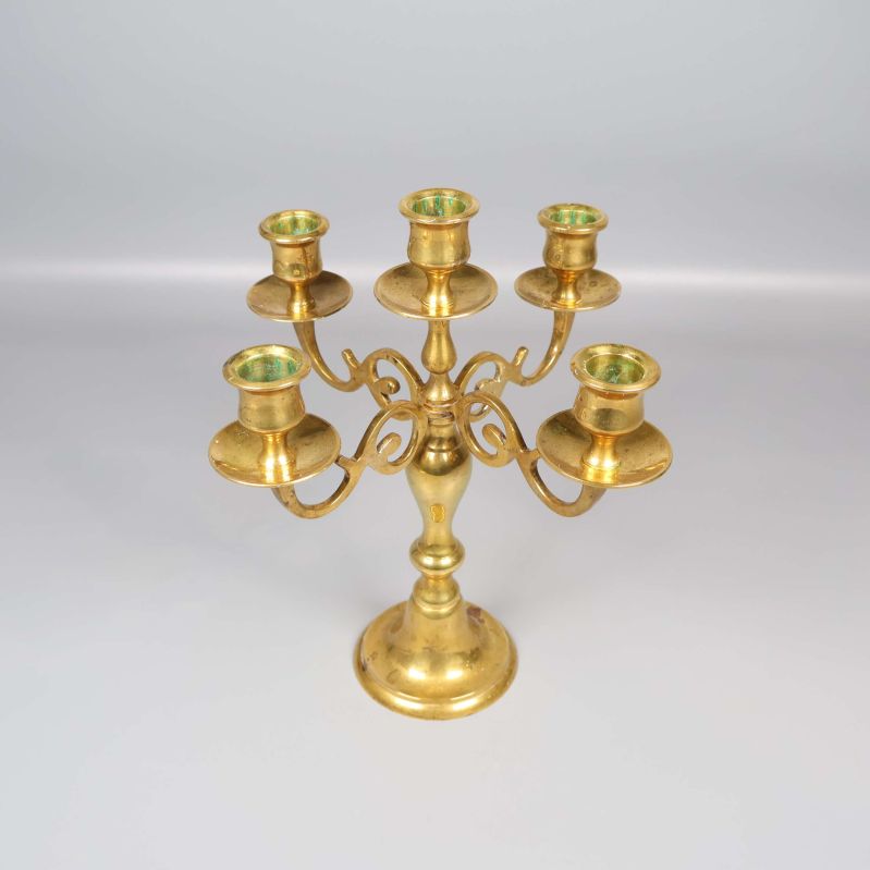 Femarmad mässingsljusstake utan ljus i ljus bakgrund