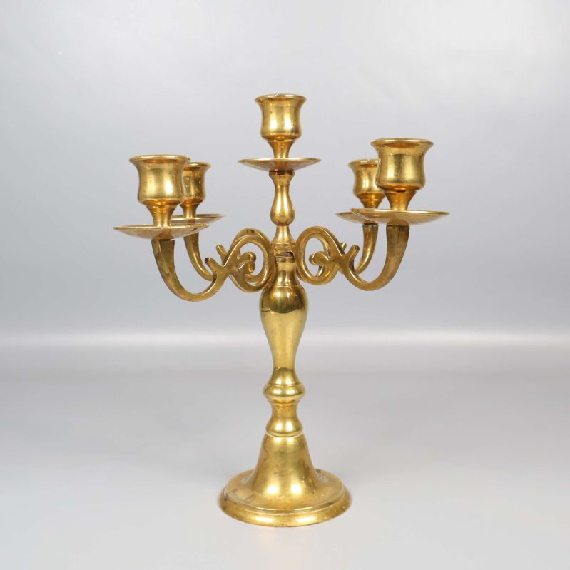 Närbild framifrån på mässingsljusstakens fem armar