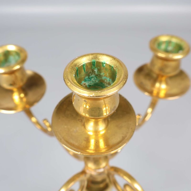 Närbild på en av mässingsljushållarna i ljusstaken