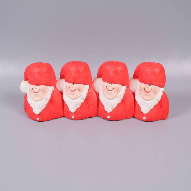 Fyra tomtar i rött som ljusstake set mot grå bakgrund