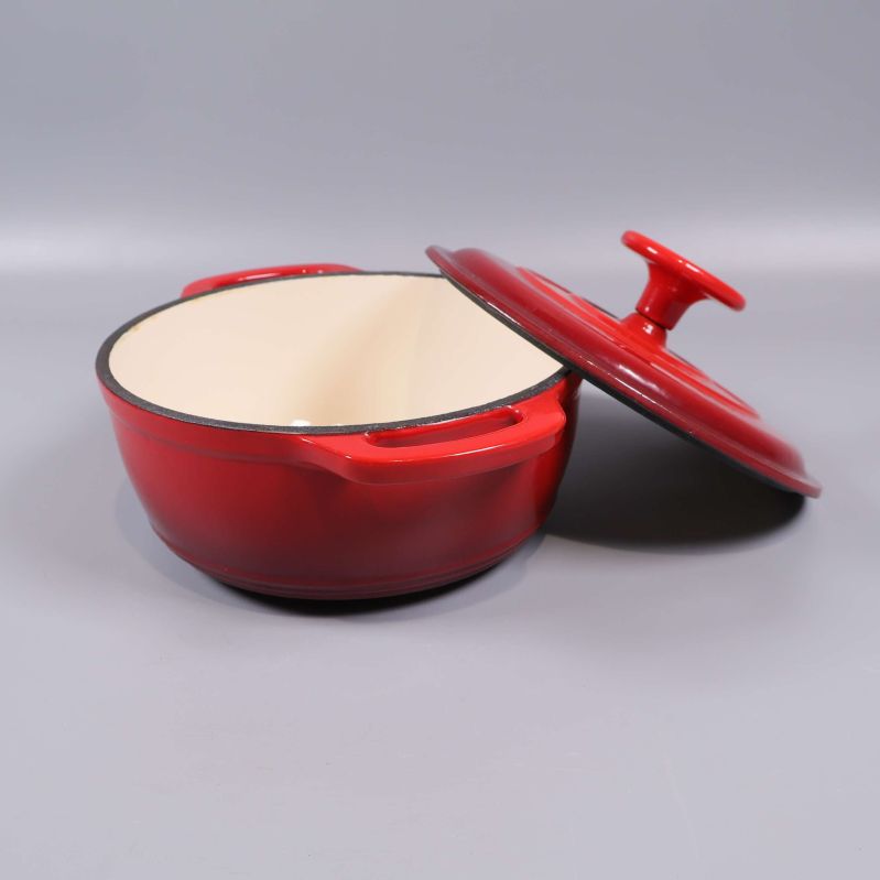 Röd gryta med lock snett lutad på sidan