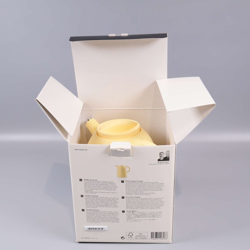 Gul termoskanna placerad i öppen kartongförpackning