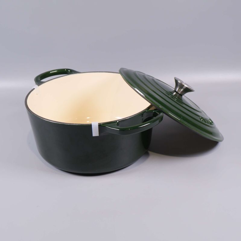 Gjutjärnsgryta med avlyft lock, visar ljus insida