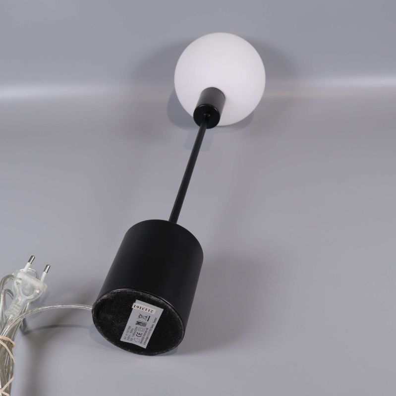 Lampa liggande med synlig strömkabel och bas