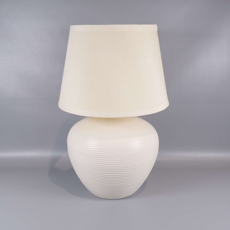 Bordslampa med räfflad rund fot och beige skärm mot grå bakgrund