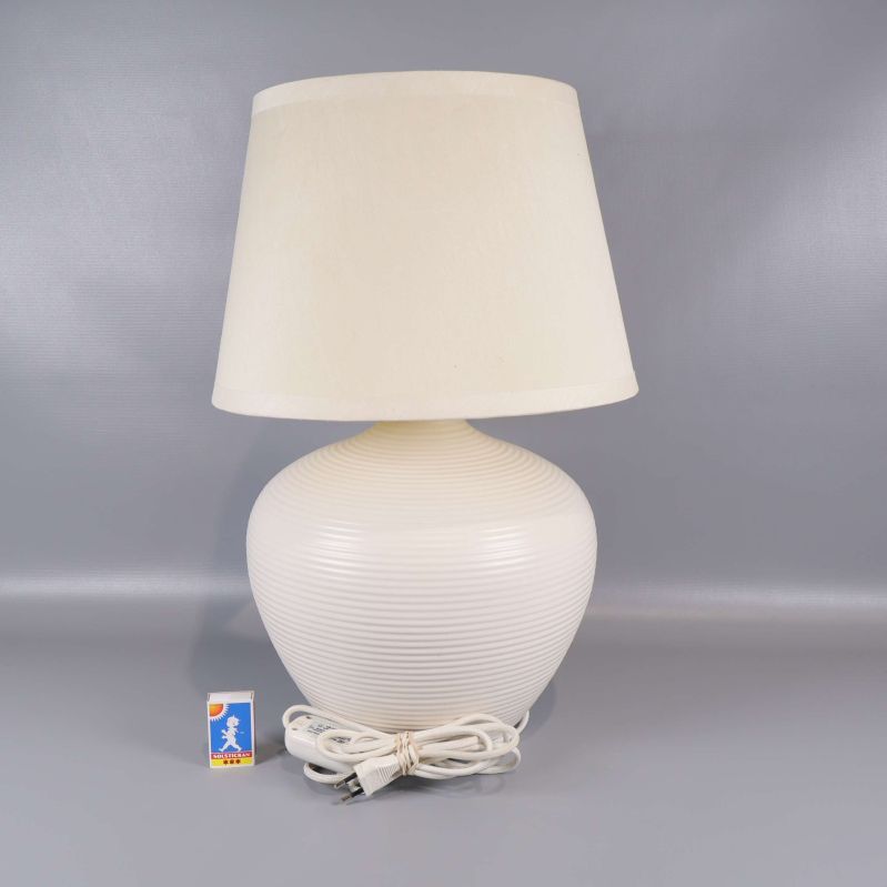 Bordslampa med synlig sladd och tändsticksask för storleksjämförelse